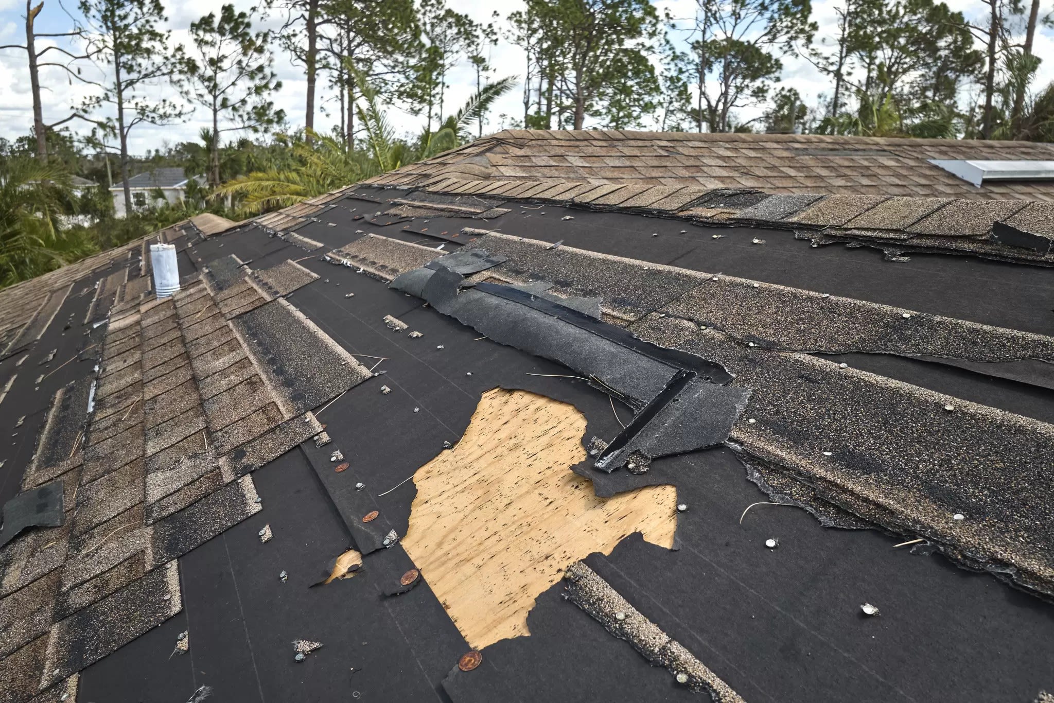 Storm-damaged roof with missing shingles after Edmonton hailstorm